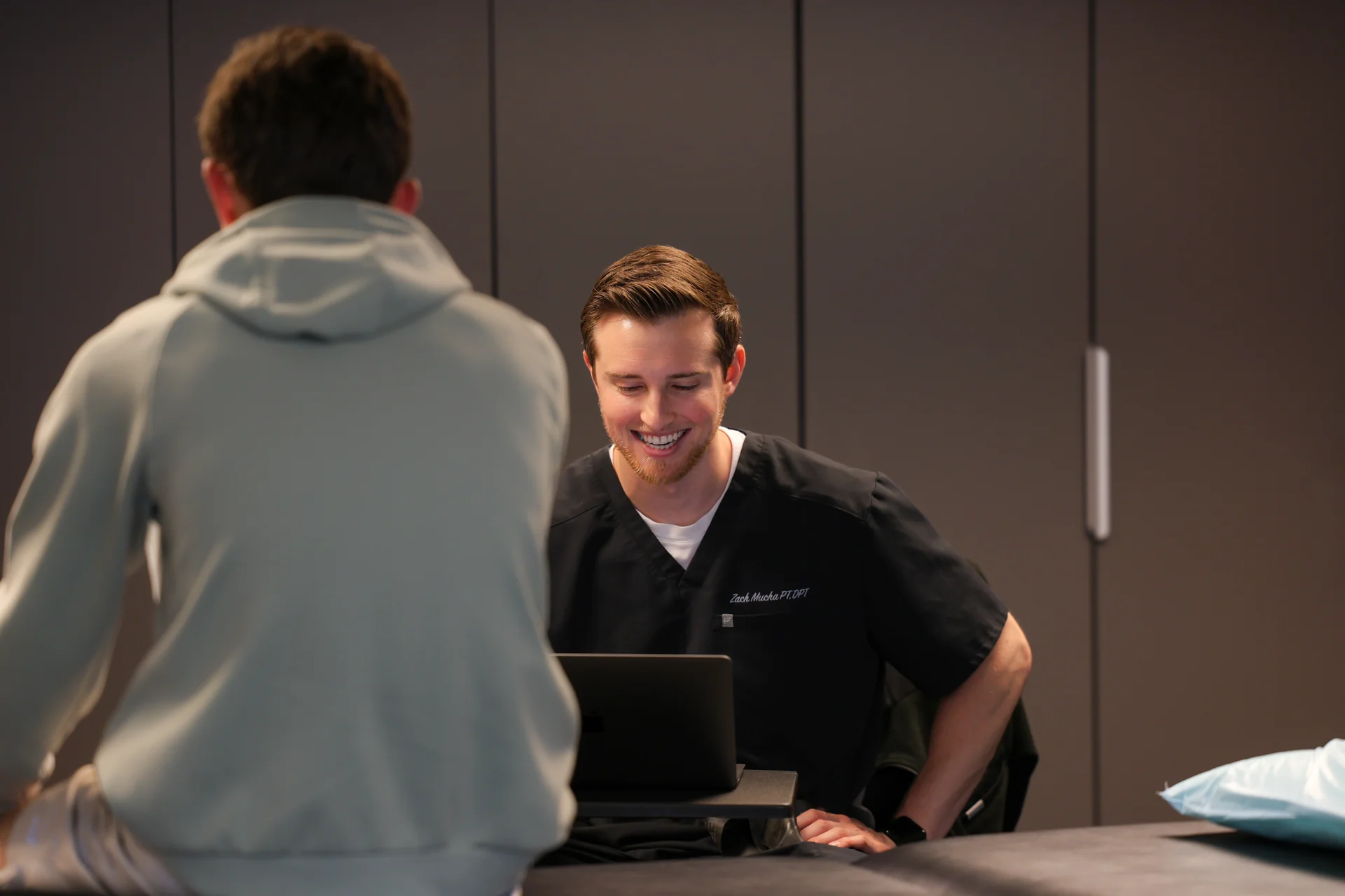 Dr. Zachary Mucha listening to a patient at TheraRehab
